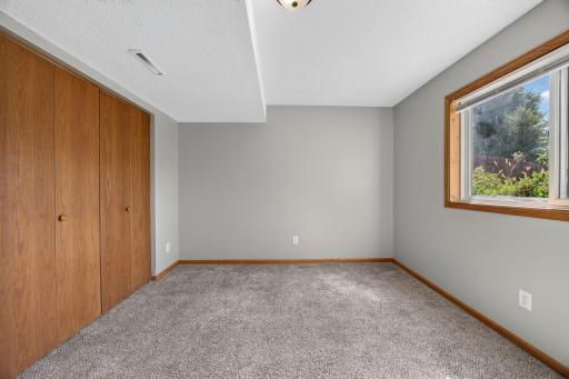 Bright and clean lower-level bedroom featuring spacious closets with plenty of room for storage.