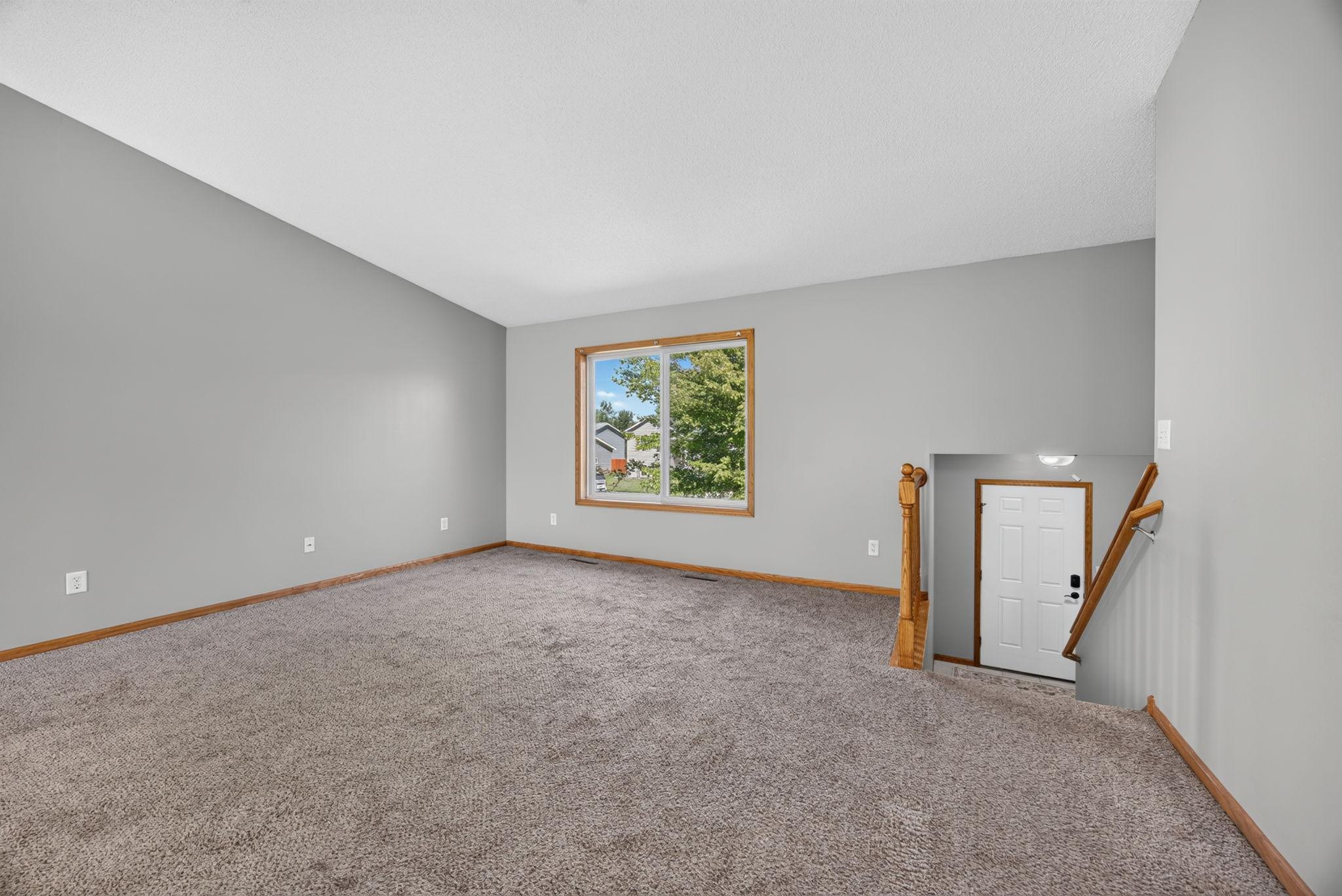 Spacious living room featuring a large front window that fills the space with natural light. It’s the perfect place to entertain friends and family or simply relax and unwind at the end of the day.