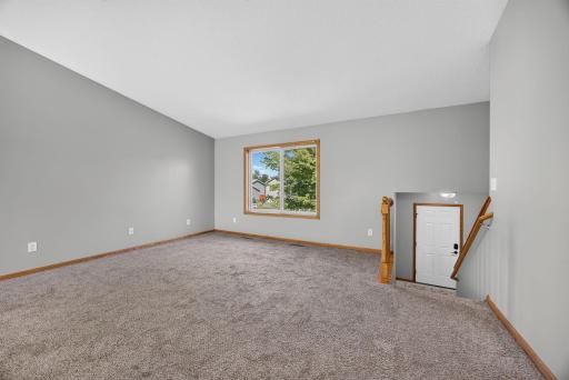 Spacious living room featuring a large front window that fills the space with natural light. Itâs the perfect place to entertain friends and family or simply relax and unwind at the end of the day.