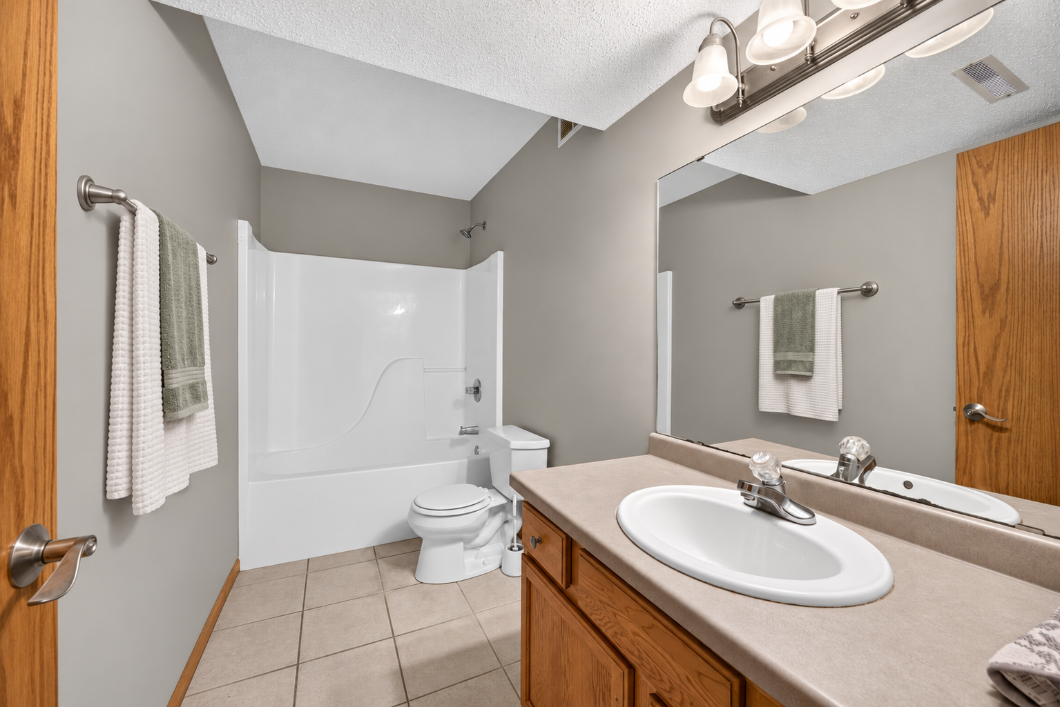 Convenient lower-level full bathroom featuring a tub/shower combination and plenty of space for everyday use or guests. AI Staged.