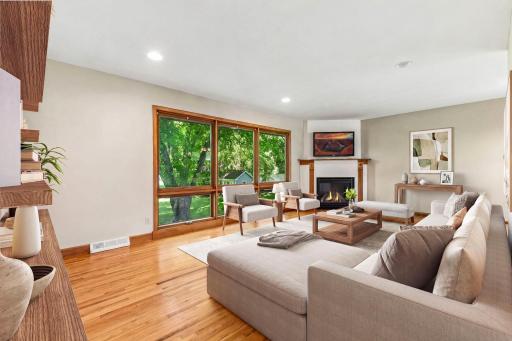 This room enjoys ambiance from a gas-burning fireplace and a wall-of-windows that frame mature trees in the backyard - *VIRTUALLY STAGED*