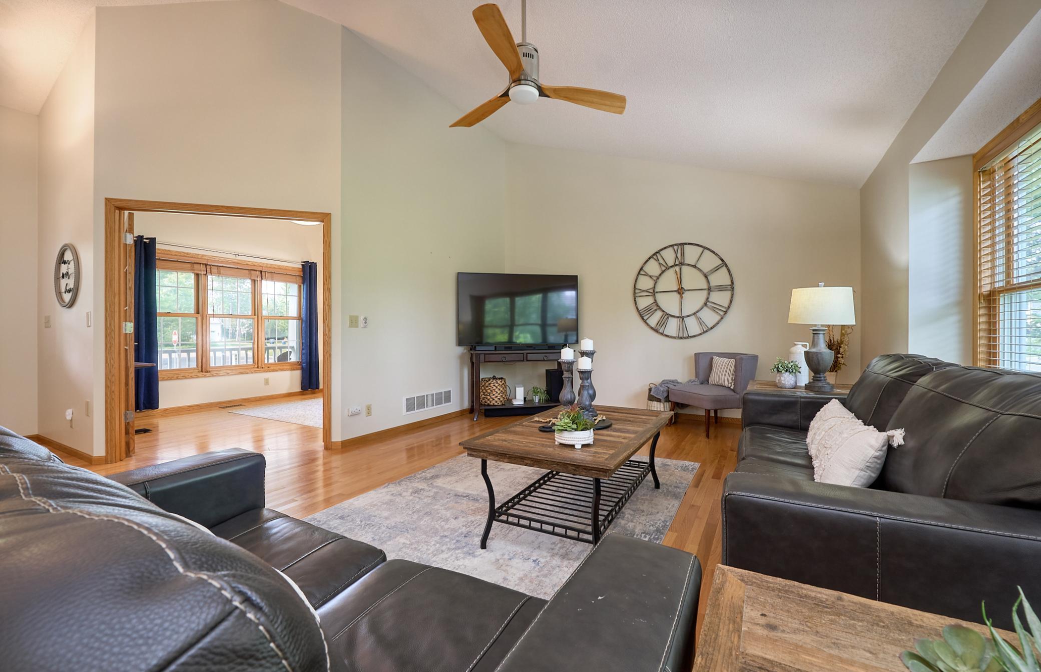 Vaulted ceilings and large windows fill this open Living Room with natural light