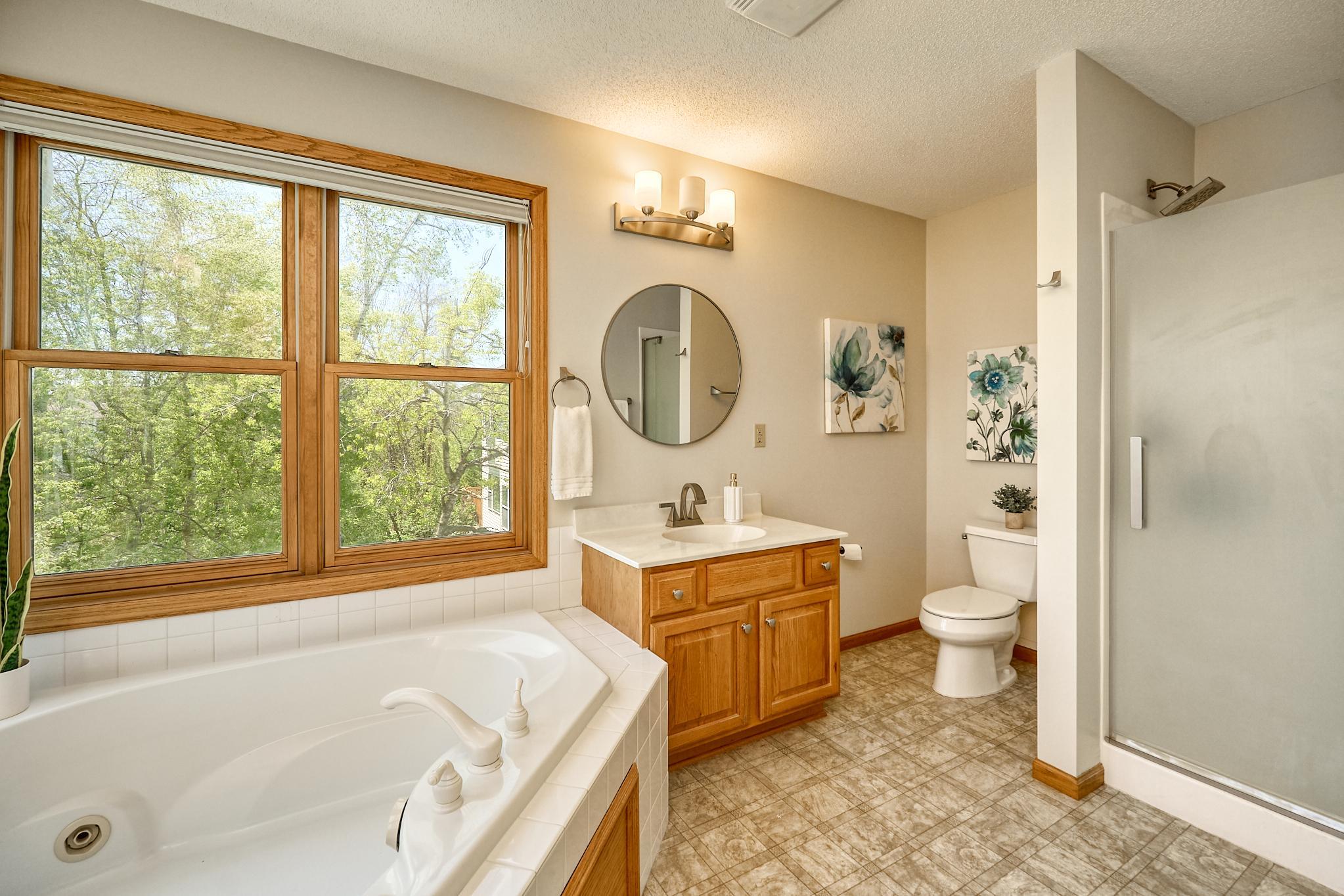 Primary Bedroom Suite with corner tub, two separate vainities, and step-in shower