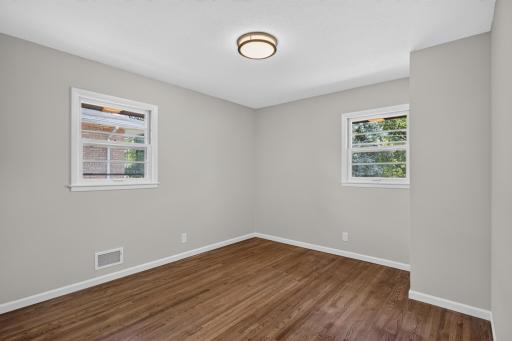 Bedroom 2 with fresh paint and refinished hardwood floors.