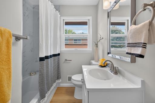 Main level full bathroom with new tile surround, vanity, toilet and LVP flooring.