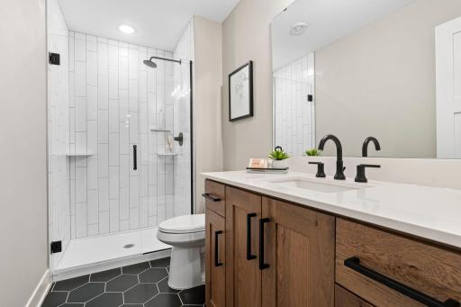 Updated lower level bathroom featuring modern fixtures, spacious vanity and walk in shower.