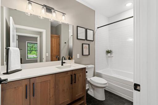 Stylish main level bathroom with spacious vanity, modern fixtures and tub/shower combination.