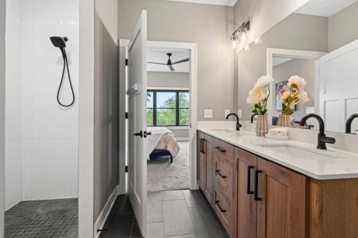 Private primary bath with walk in tile shower and convenient connection to the primary bedroom.