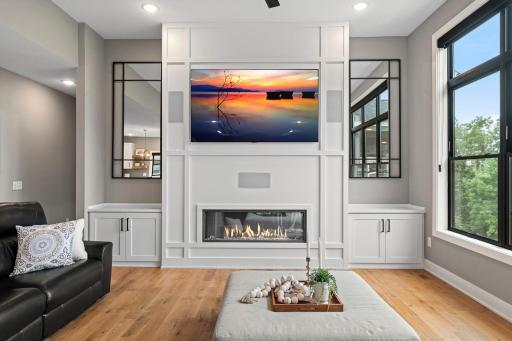 Modern electric fireplace with custom surround, built in cabinetry and contemporary finishes.