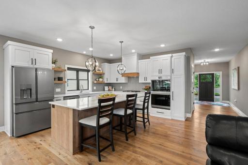 Beautiful kitchen featuring generous cabinetry, stainless steel appliances and real wood flooring.