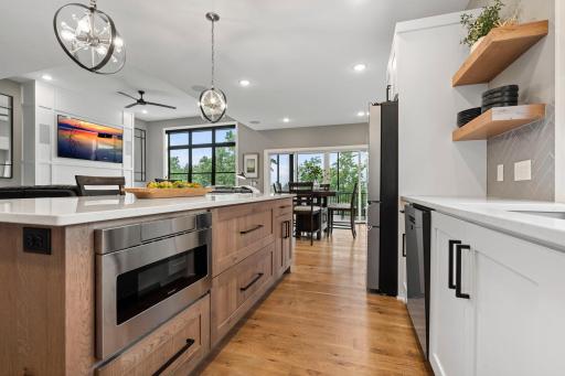 Large kitchen center island provides built-in microwave and seating with an open view into the dining area.
