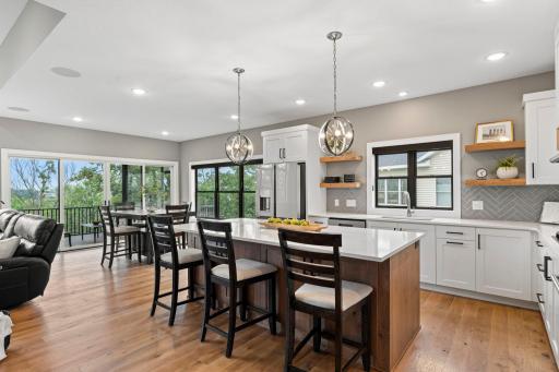 Open concept kitchen and dining area featuring a large center island, pendant lighting and beautiful natural light.