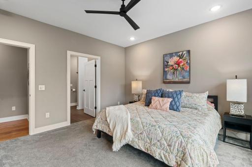 Comfortable primary bedroom with neutral finishes and convenient access to the private primary bath.