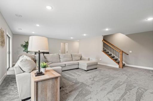 Spacious lower level living area with recessed lighting, neutral finishes and flexible space for multiple seating areas.