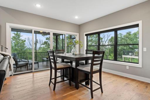 Bright dining area surrounded by large windows with beautiful views and convenient access to the screened porch.