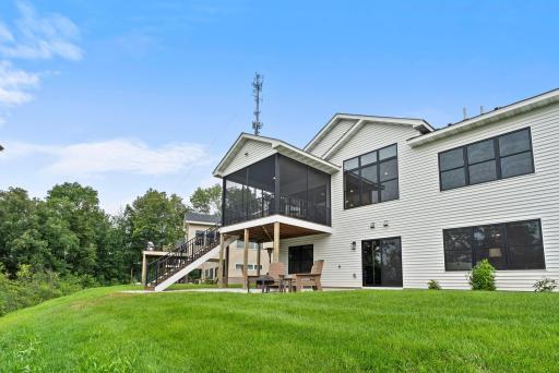 Rear exterior highlights the screened porch, walkout lower level, patio and multiple outdoor living spaces.