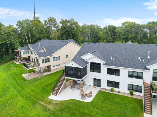 Aerial view of the home showcases the screened porch, walkout design, backyard and beautiful setting.