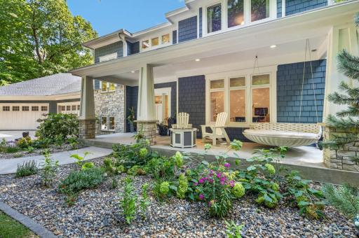 Inviting front porch features tapered craftsman style columns with ledgestone bases and concrete floor
