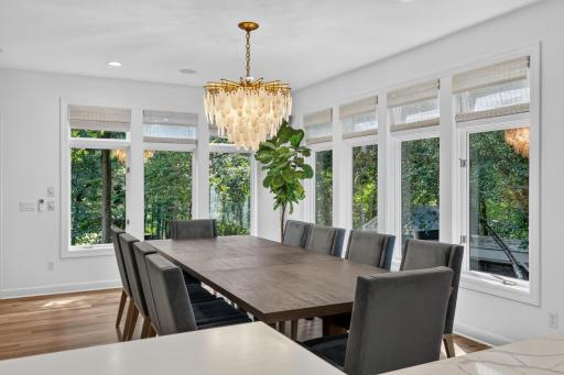 Dining Room features floor to ceiling windows provide panoramic views of the naturally wooded property