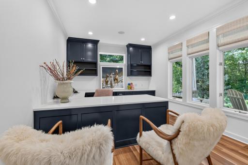 The office features French full glass doors, crown molding and a custom enameled built-in workstation and credenza
