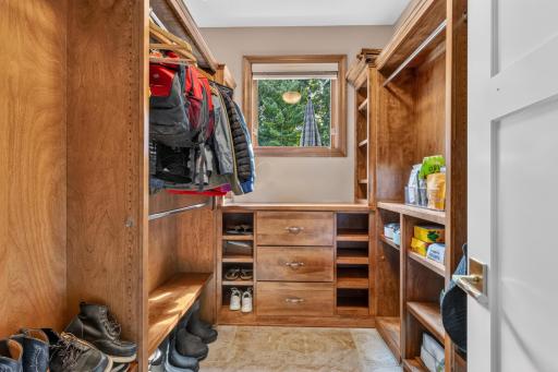 Large walk-in closet with alder cabinetry and natural light