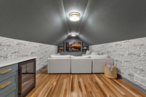 Bonus Room features charmer dormer ceilings and decorative wall coverings. Built-in beverage center offers enameled cabinetry, quartz top, ZLine microwave and beverage refrigerator