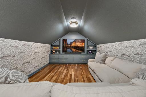 Built-in entertainment cabinet features drawer and door storage, open display shelving and large opening for a modern TV