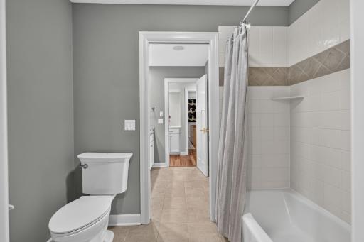Walk-through Full Bathroom features pocket door access to the tub and toilet. Ceramic tile tub surround