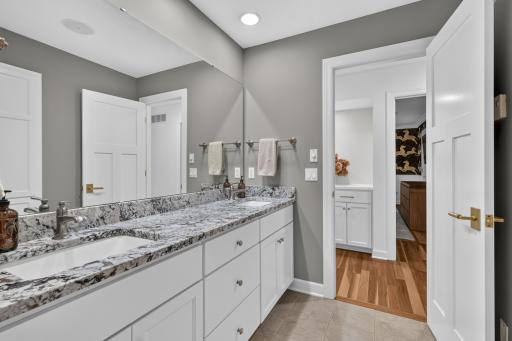 Enameled vanity cabinet with granite top and dual sinks