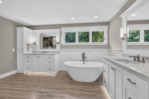 Master Bathroom features dual enameled vanities with quartz countertops, kick-toe accent lighting, linen tower, under-mount sinks and wide spread faucets