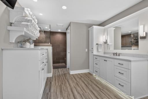 Enameled built-in dresser with laundry bin pull-outs quartz countertop and white oak floating shelves