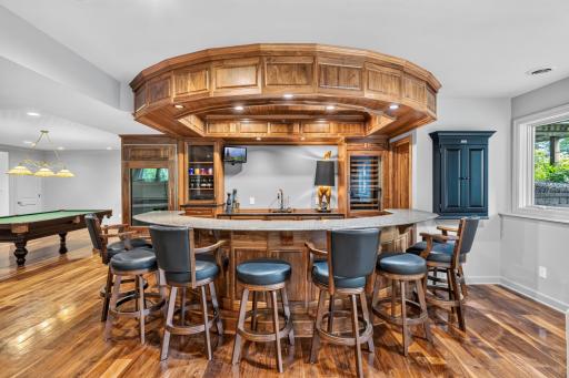 Full bar features black walnut raised paneled doors, pair of SubZero full height cabinet paneled / full glass beverage refrigerators w/ freezer drawer and Fisher & Paykel cabinet paneled dishwasher drawer.