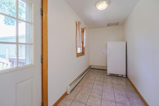 This back porch area can be your pantry, mud room, drop zone, or flexible space. It has tile flooring and leads to the deck.