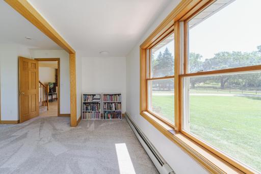 The nook area in the main floor bedroom makes a unique alcove for closet or a desk space. It overlooks a charming split-rail fence and the front yard.