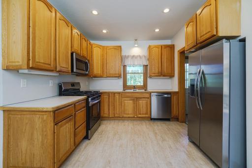 The kitchen features stainless steel appliances, including a gas range, dishwasher and microwave.
