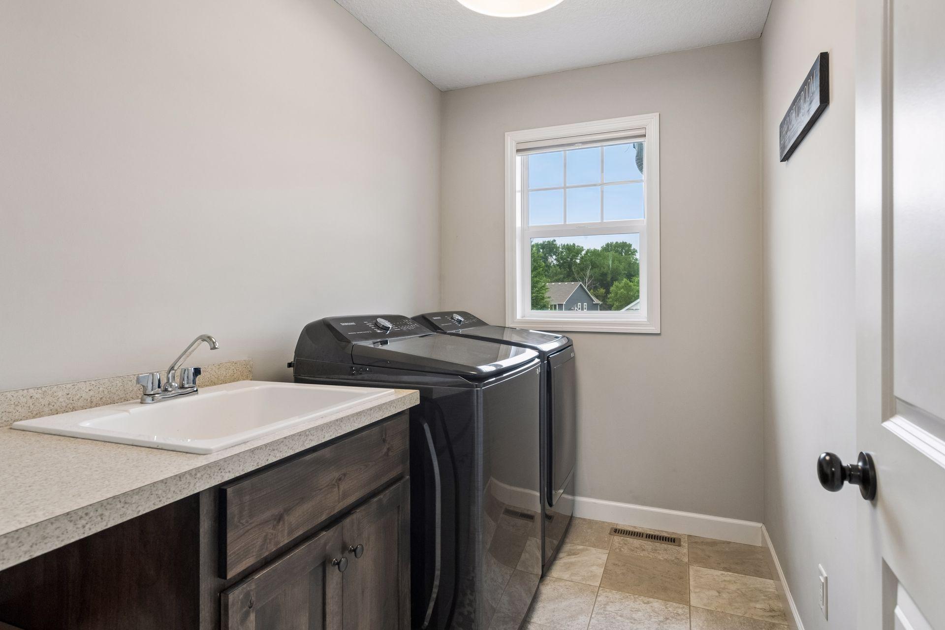 Upper level laundry room with sink and folding area.