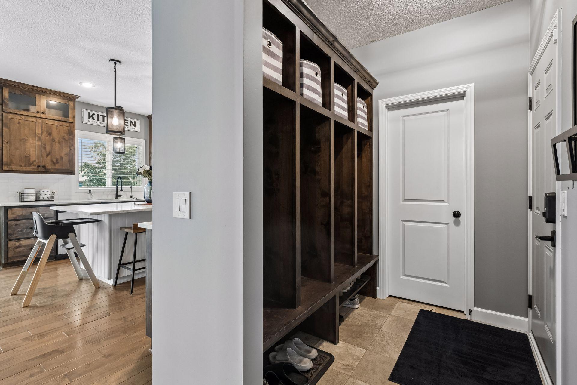 Entrance off garage with built-in lockers and walk-in closet.