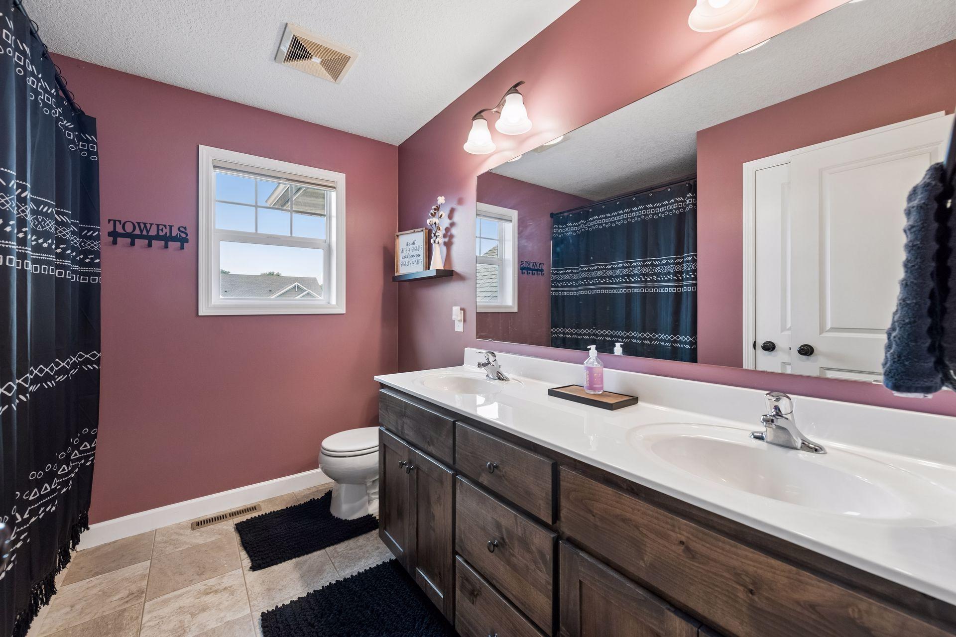 Shared upper level bath features dual vanity and tub/shower combo