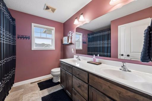 Shared upper level bath features dual vanity and tub/shower combo