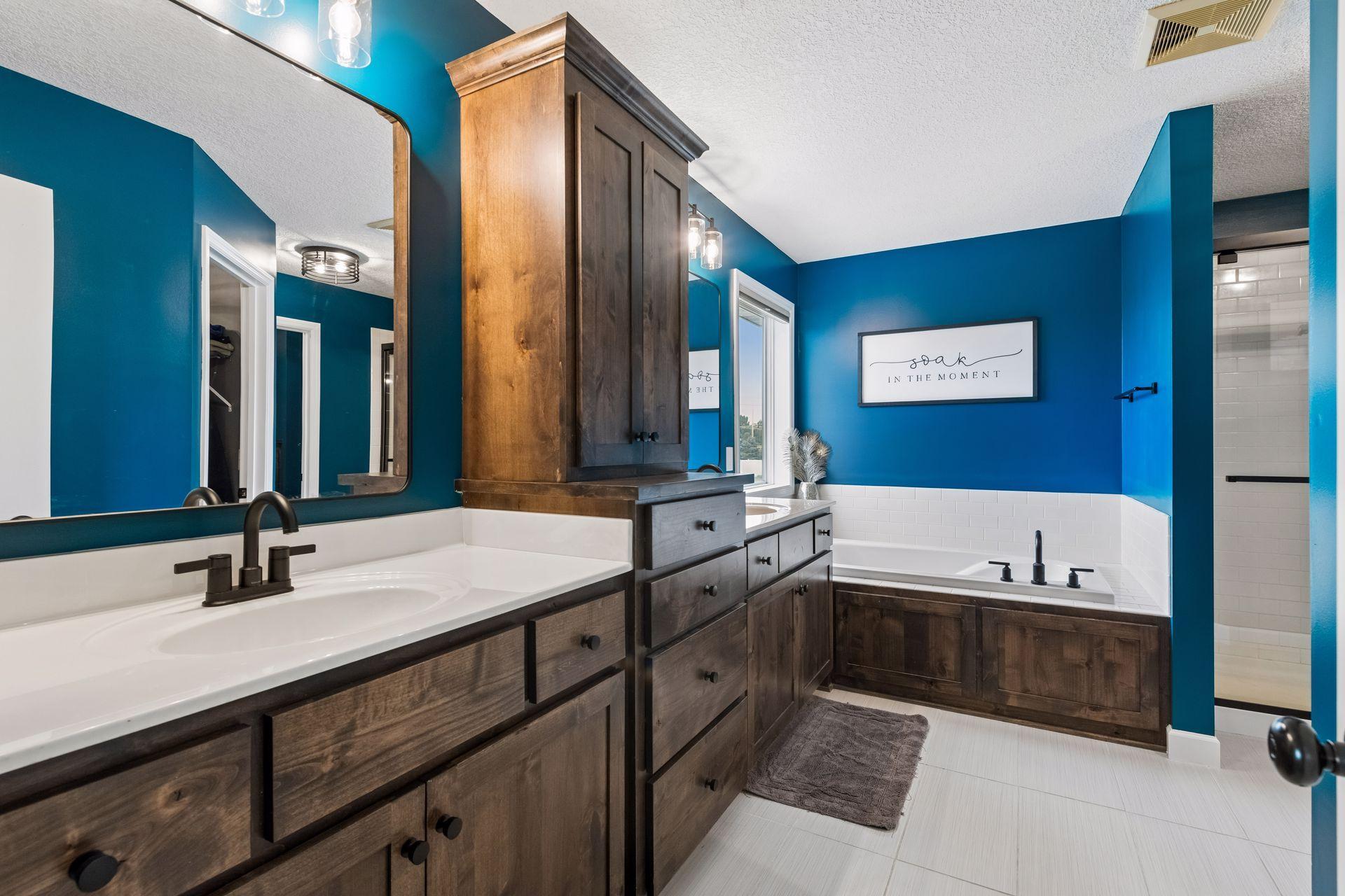 En-suite bath with dual vanity, custom cabinets, tile floors, soaking tub and separate shower.