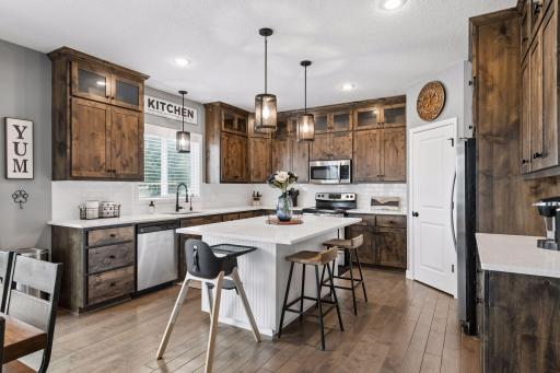 Custom kitchen features gorgeous custom cabinets, large island, walk-in pantry and coffee bar!
