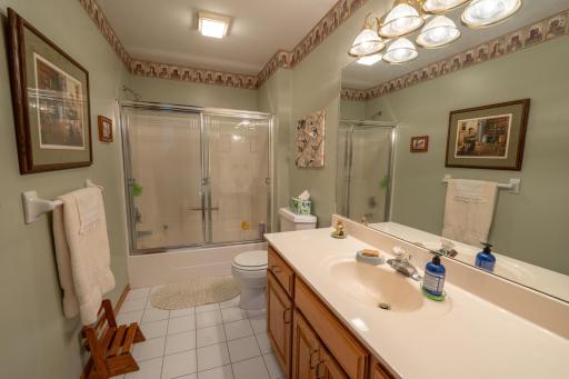 This is the second full bathroom on the upper level near the 2nd and 3rd bedrooms. There is a tub as well as a shower along with tile floors and custom lighting
