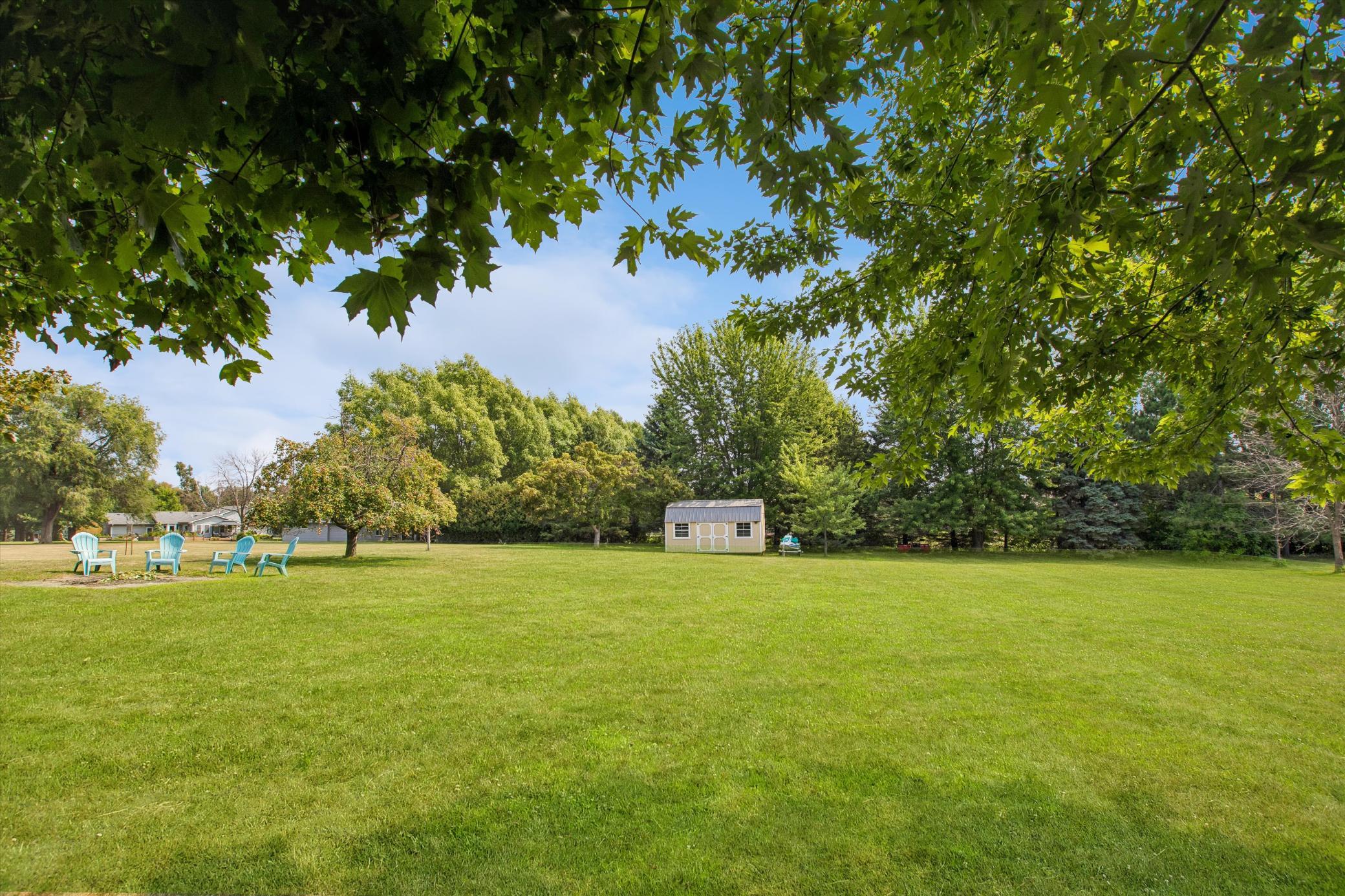 Huge 1 acre lot with view of the 10'x20' shed and fire pit.