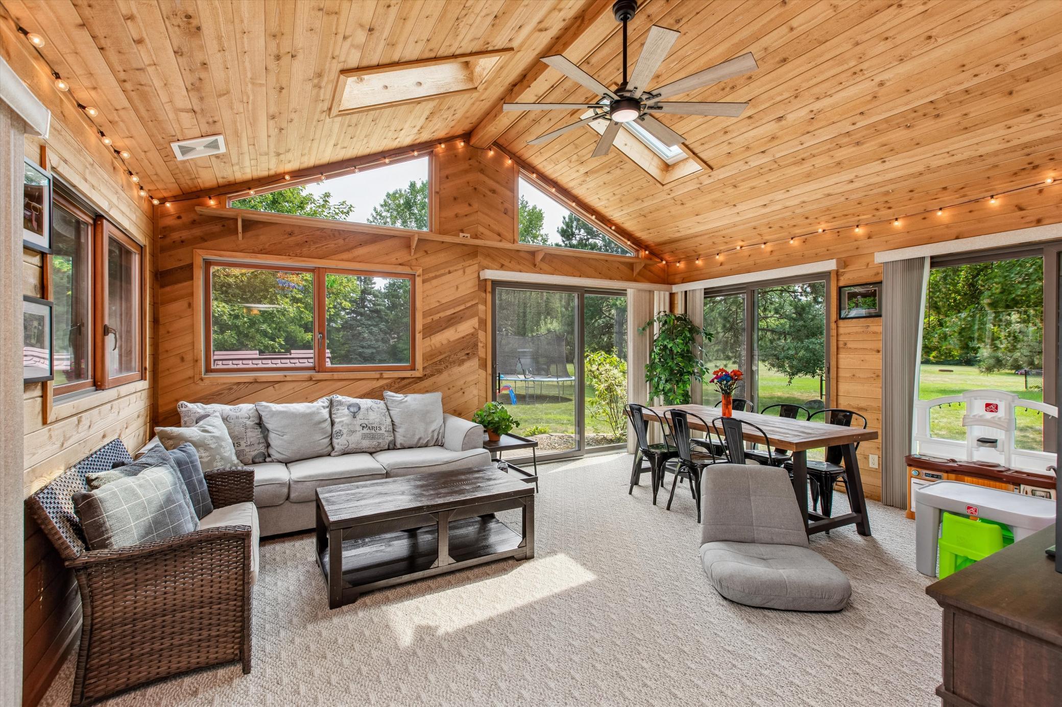 Sunroom with vaulted ceiling, 2 patio doors to the backyard.