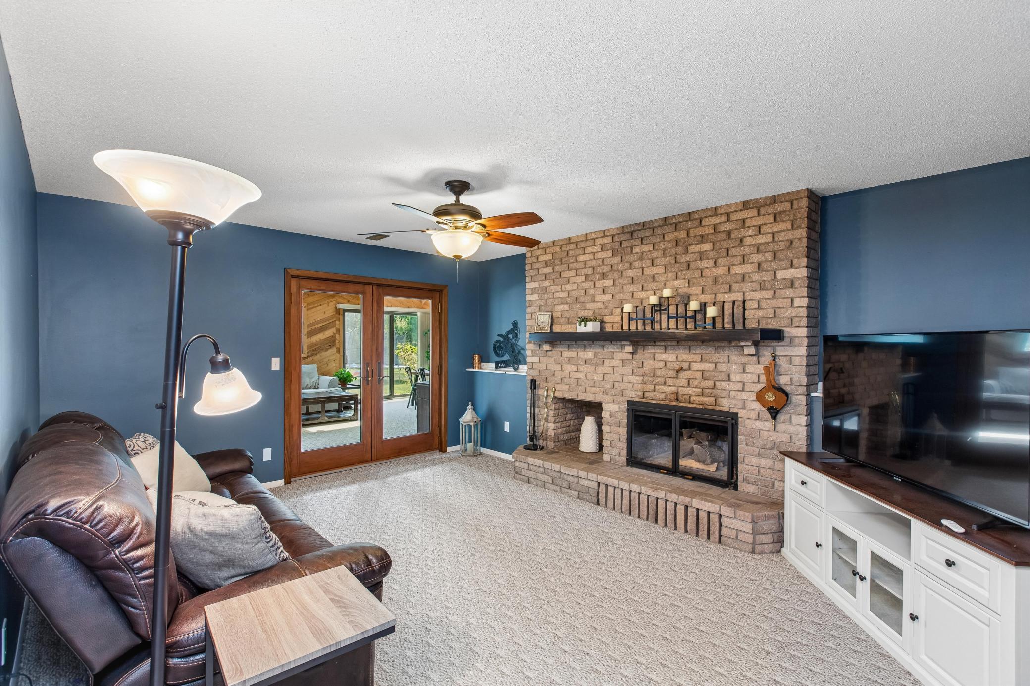 LL family room with wood burning fireplace and entrance to the sunroom.