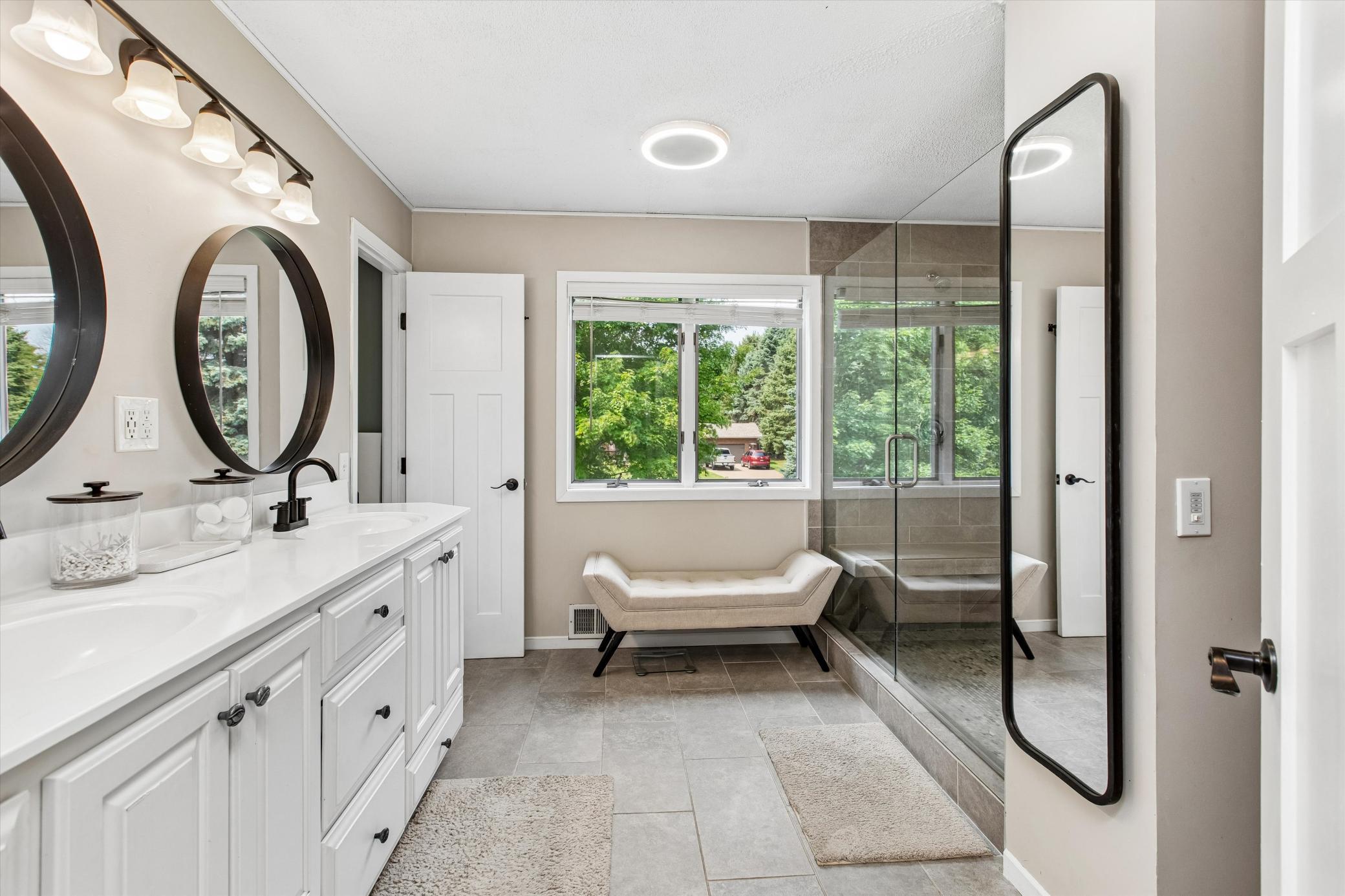 upper level bathroom with double sink vanity and large walk-in shower.
