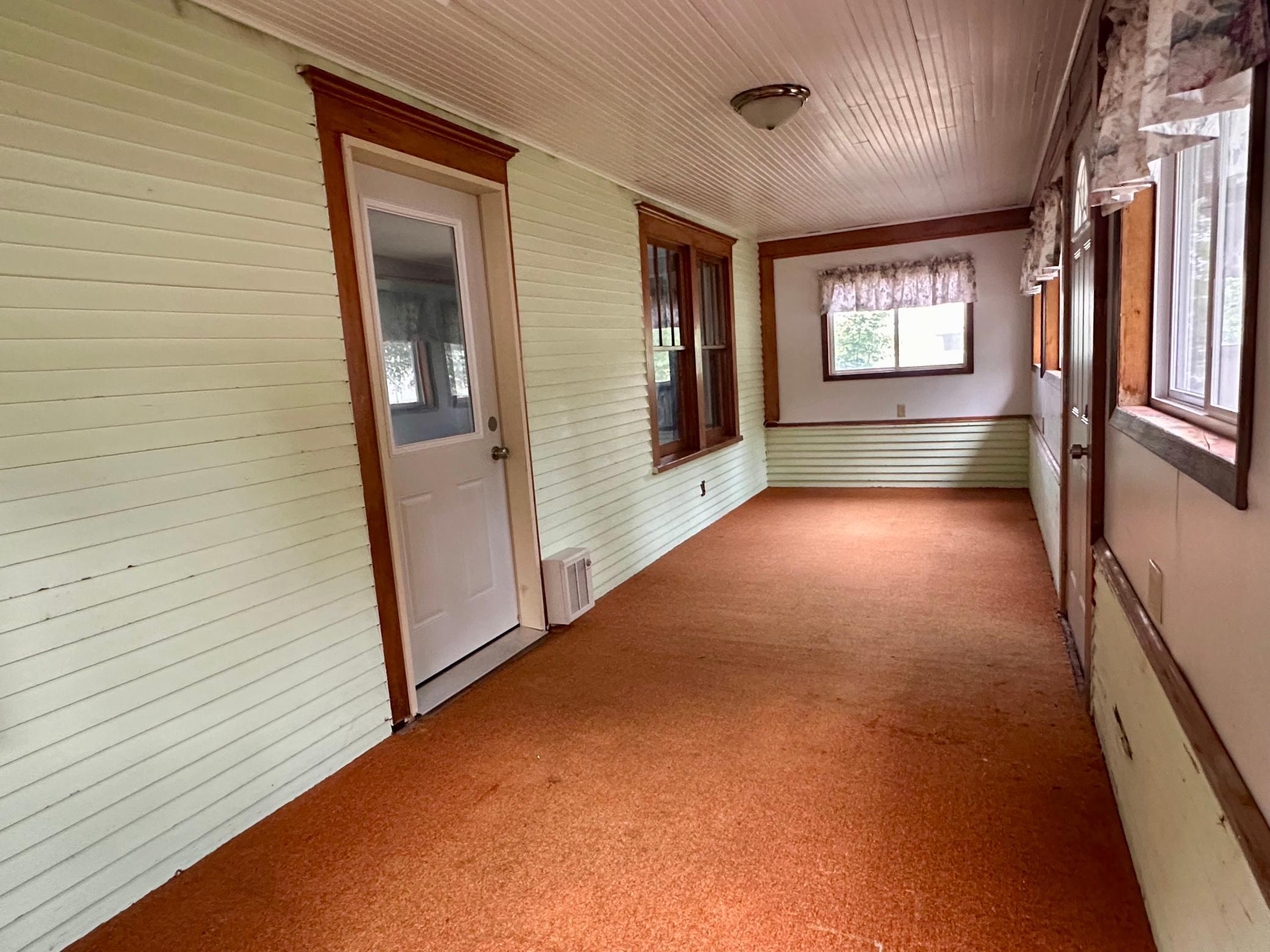 Step up five stairs onto the front deck and enter into the front three-season porch.