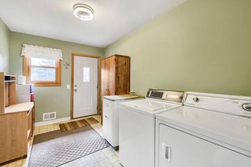 This upper level laundry room includes a closet and a door to the back yard.