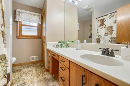 Full bath with tub/shower and beautiful hard surface counter tops.