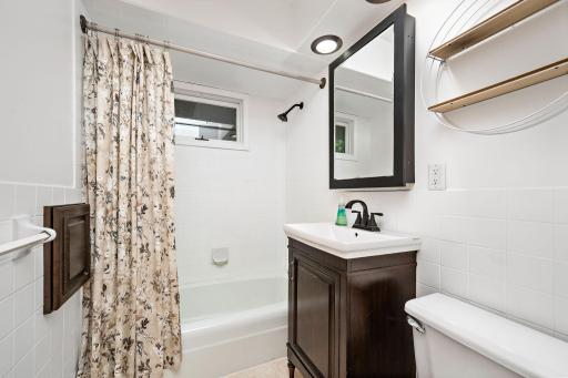 Updated main-floor full bathroom featuring a clean, modern vanity, stylish fixtures and a convenient tub/shower combination.